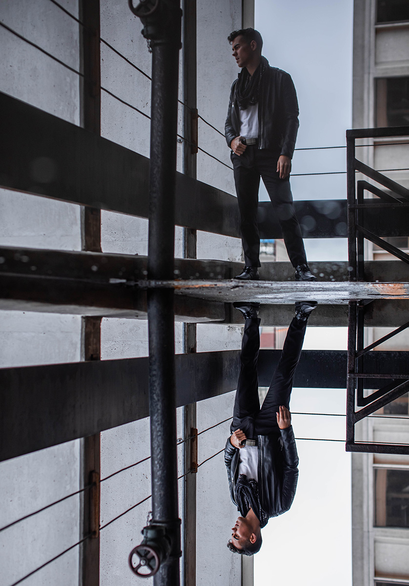 male model standing near water